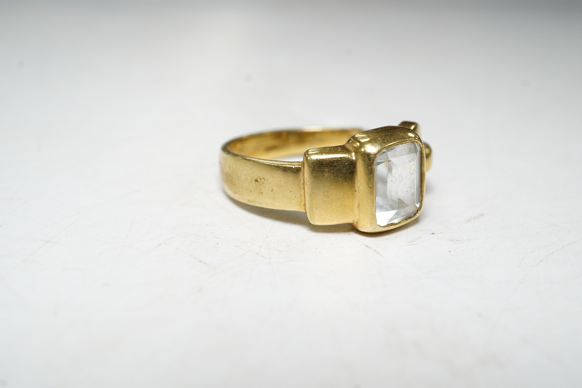 An 18ct gold aquamarine set buckle ring, size O, gross 6.1 grams Condition, fair.